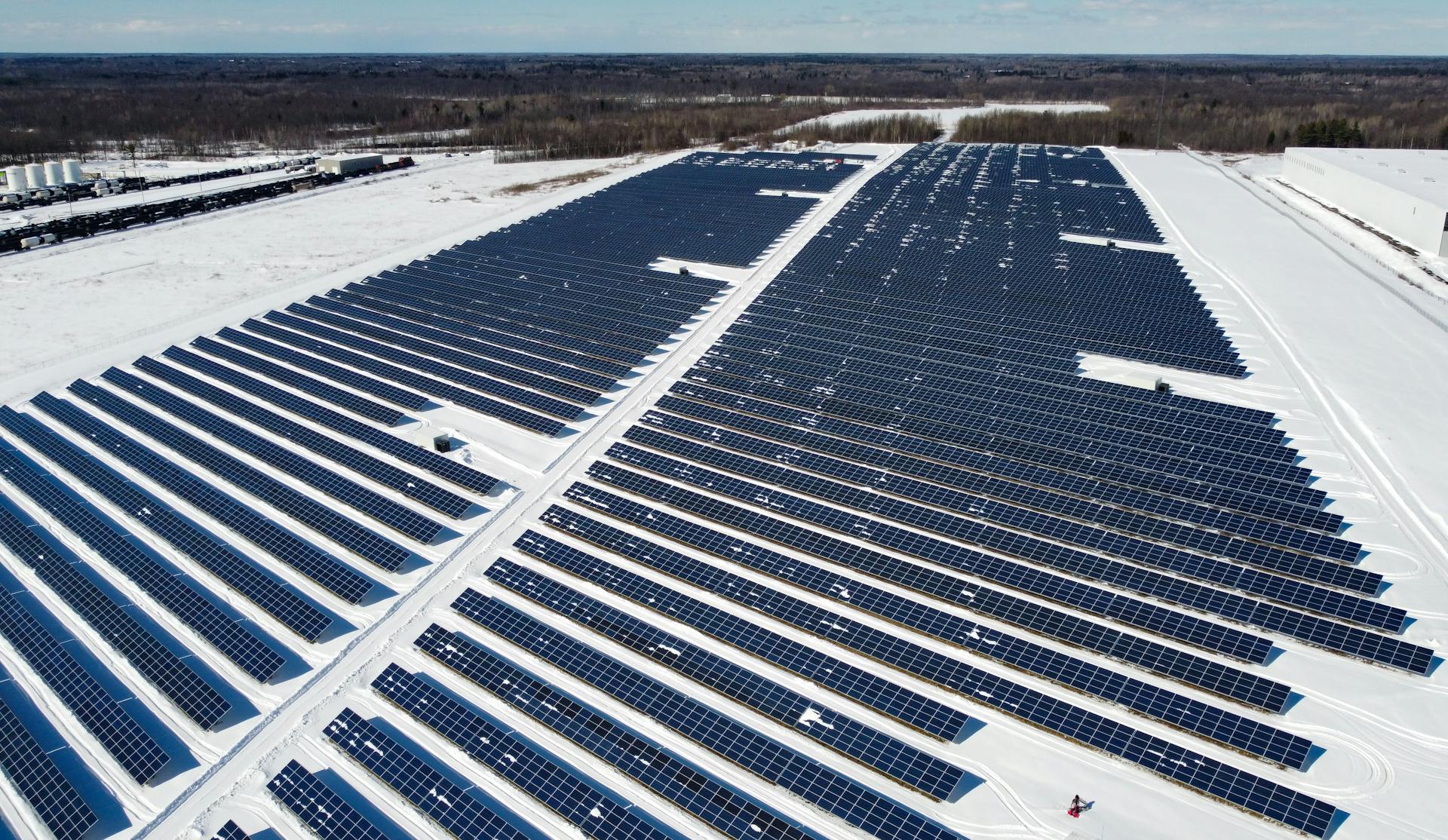Drone Solar Panel Inspection Aerial drone image of a large solar panel farm in winter, ideal for inspection and maintenance services.