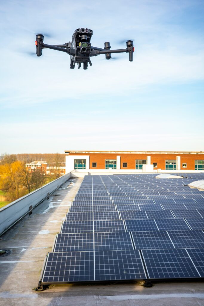 A DJI enterprise drone conducting aerial mapping and inspection of rooftop solar panels on a commercial building
